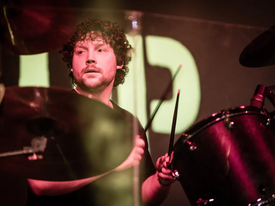 Andrew mid-song with sticks raised